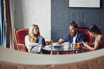 Friends, relax and group with coffee in cafe, conversation and social gathering on break or bonding. Restaurant, hospitality and people with phone on weekend, customer and talking with caffeine drink