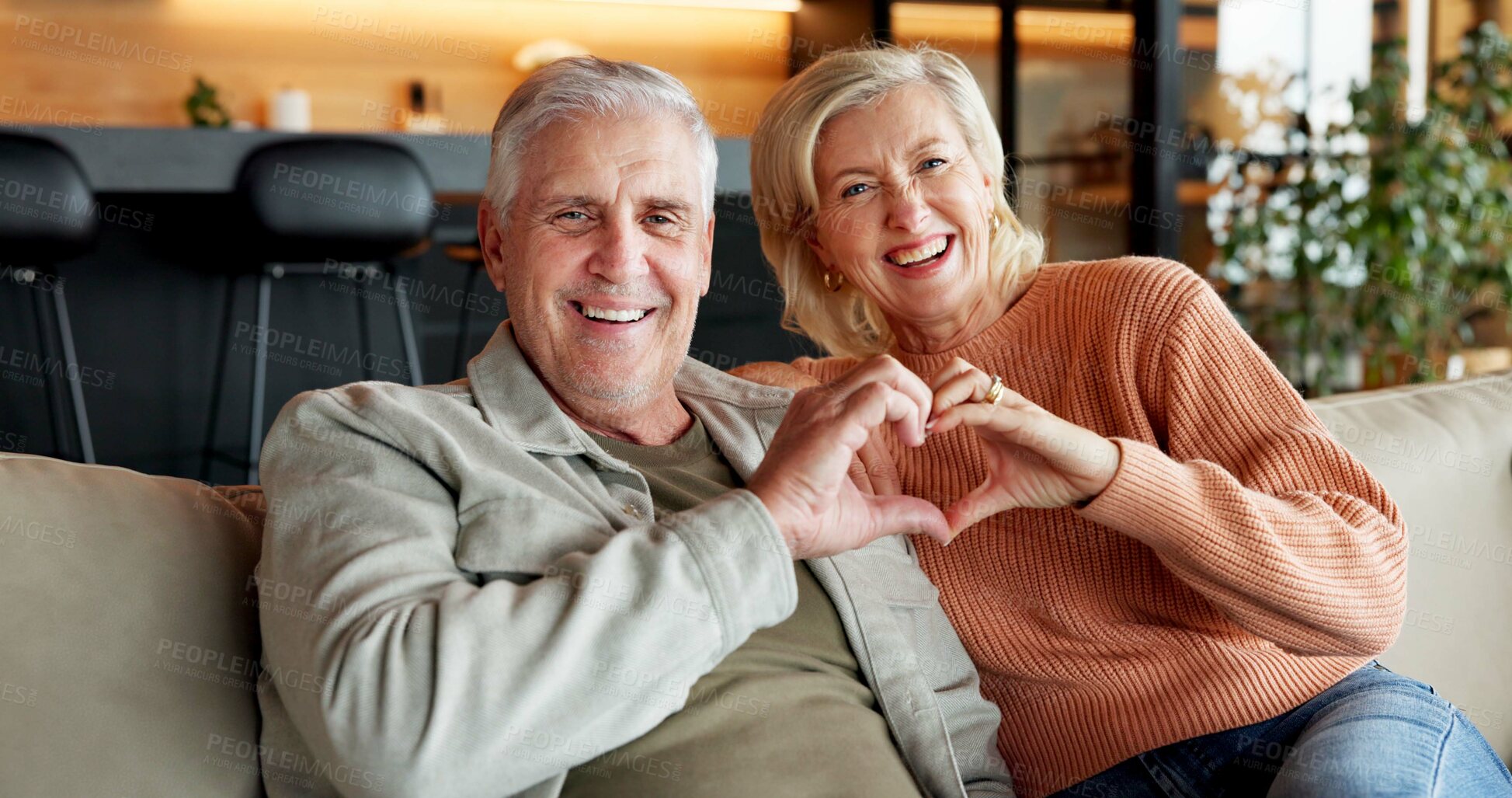 Buy stock photo Home, portrait and senior couple with heart, laugh and connection with partner on break or affection. Happy, mature people and bonding on weekend, comfortable and commitment with love shape in house