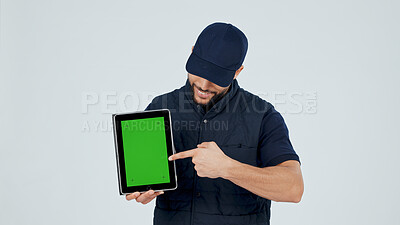 Buy stock photo Man, tablet and pointing at green screen for marketing, promotional info or app for service in studio. Employee, mockup space and advertising presentation with UI, tech and display on background