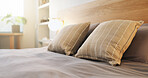 Hotel, empty and bed in room for accommodation, furniture and interior design for luxury resort. Hospitality, space and bedroom with pillows, duvet and bedding for comfort, housekeeping and clean