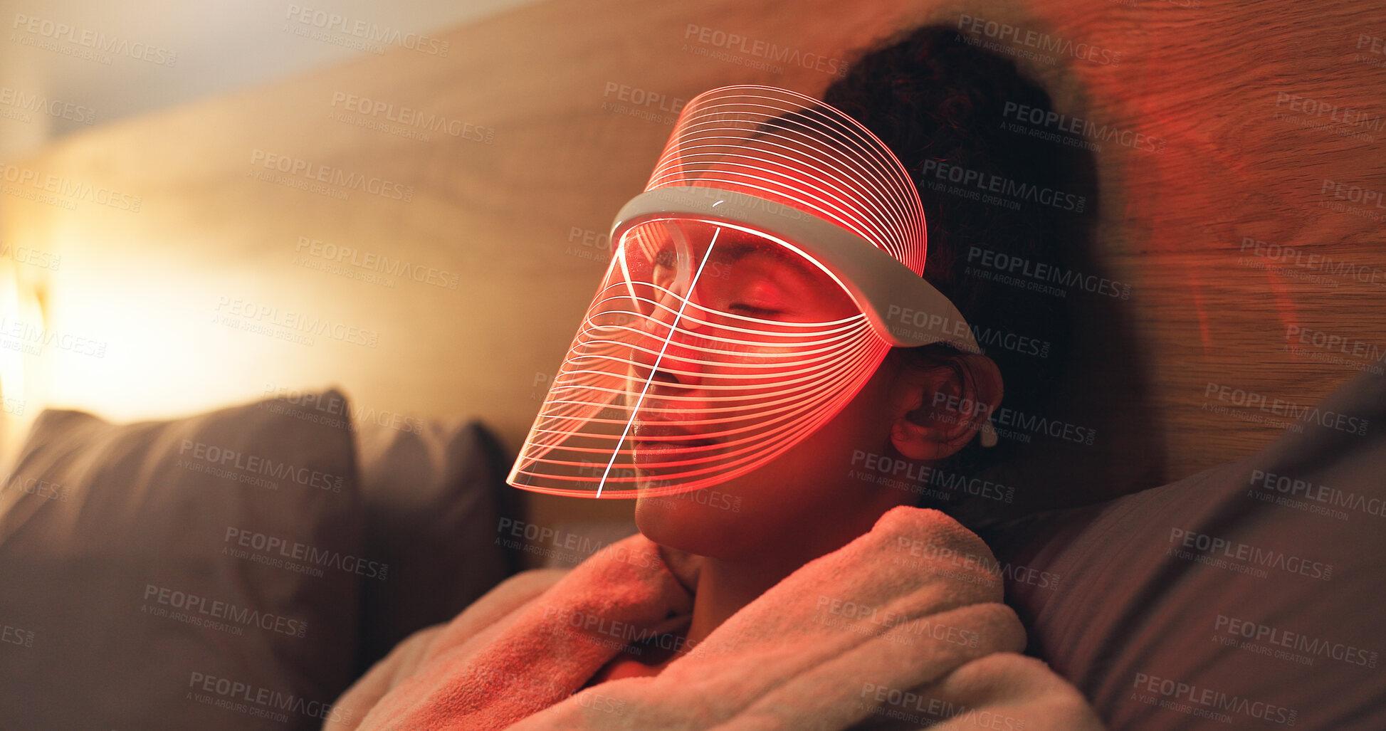 Buy stock photo Red light, mask and woman in bedroom with skincare for beauty, wellness and collagen production. Health, relax and person in bed with LED phototherapy for dermatology or facial treatment in home