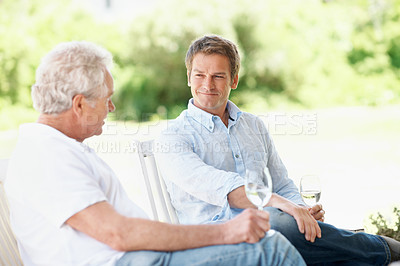 Buy stock photo Drinks, backyard and senior father for talking, conversation and relax with son on weekend. Family, outdoor and person with elderly parent, alcohol and wine for connection, relationship and visit
