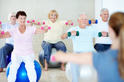 Buy stock photo Fitness, old people and weightlifting with personal trainer in studio for health or wellness. Dumbbell exercise, retirement and training with instructor in gym class for coaching or physical activity