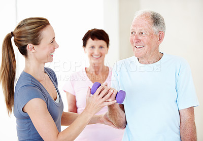 Buy stock photo Pilates, personal trainer and old man in class with dumbbells, support or fitness in retirement. Senior resident, happy instructor and weights at facility for guide, muscle wellness or exercise group