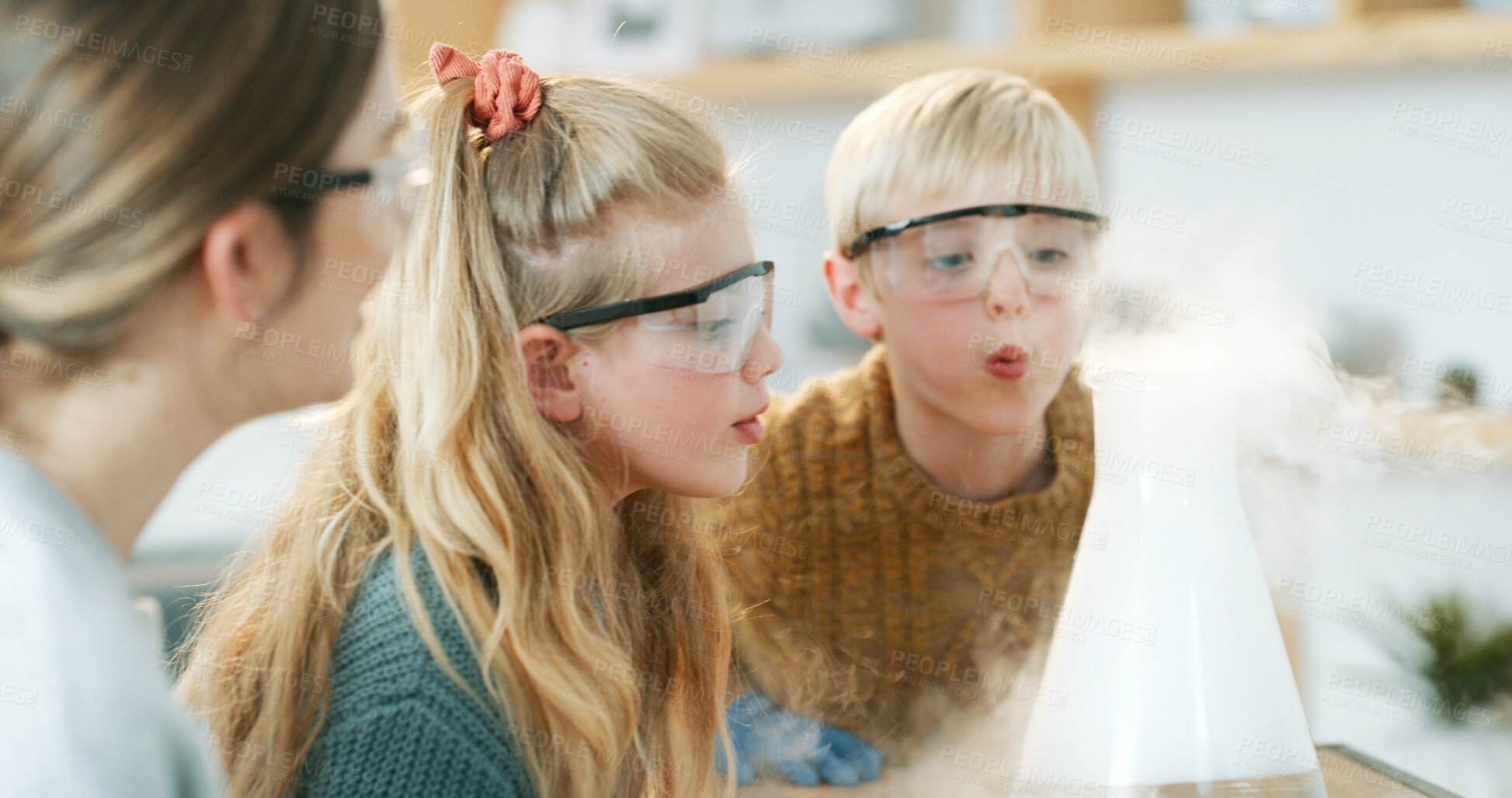 Buy stock photo Science, mom or kids with beaker in home, interactive learning or observation of chemistry experiment. Blow smoke, woman or siblings with physics discovery for knowledge, goggles or child development