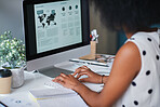 African american business woman using computer in office with financial data on screen