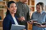 Successful business woman smiling female team leader looking confident with colleagues using tablet computer
