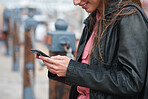 Woman using smartphone texting in waterfront harbour browsing messages on mobile phone