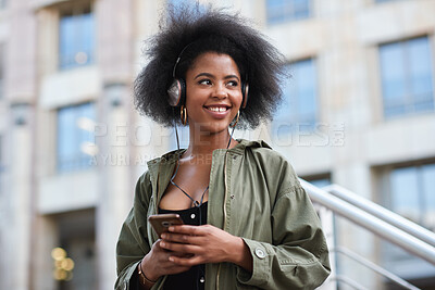 Buy stock photo Phone, headphones and black woman in city with texting, chatting or contact on mobile app with music. Cellphone, audio tech and person with connectivity on website with listening to playlist in town.