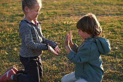 Buy stock photo Friendship, hand game and children on field with fun, holiday together and bonding on weekend break. Playful, boy or girl with patty cake, youth vacation or peer connection in childhood activity.