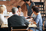 Mulit ethnic business people meeting around a boardroom table discussing strategy