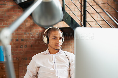 Buy stock photo Business, computer and music with designer man in office for planning or research with headphones. Pc, reading and design employee in creative workplace for administration, email feedback or audio