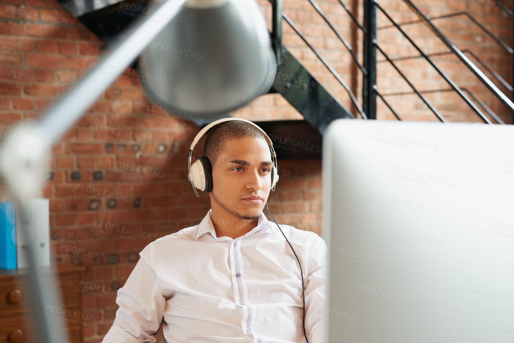Buy stock photo Business, computer and music with designer man in office for planning or research with headphones. Pc, reading and design employee in creative workplace for administration, email feedback or audio