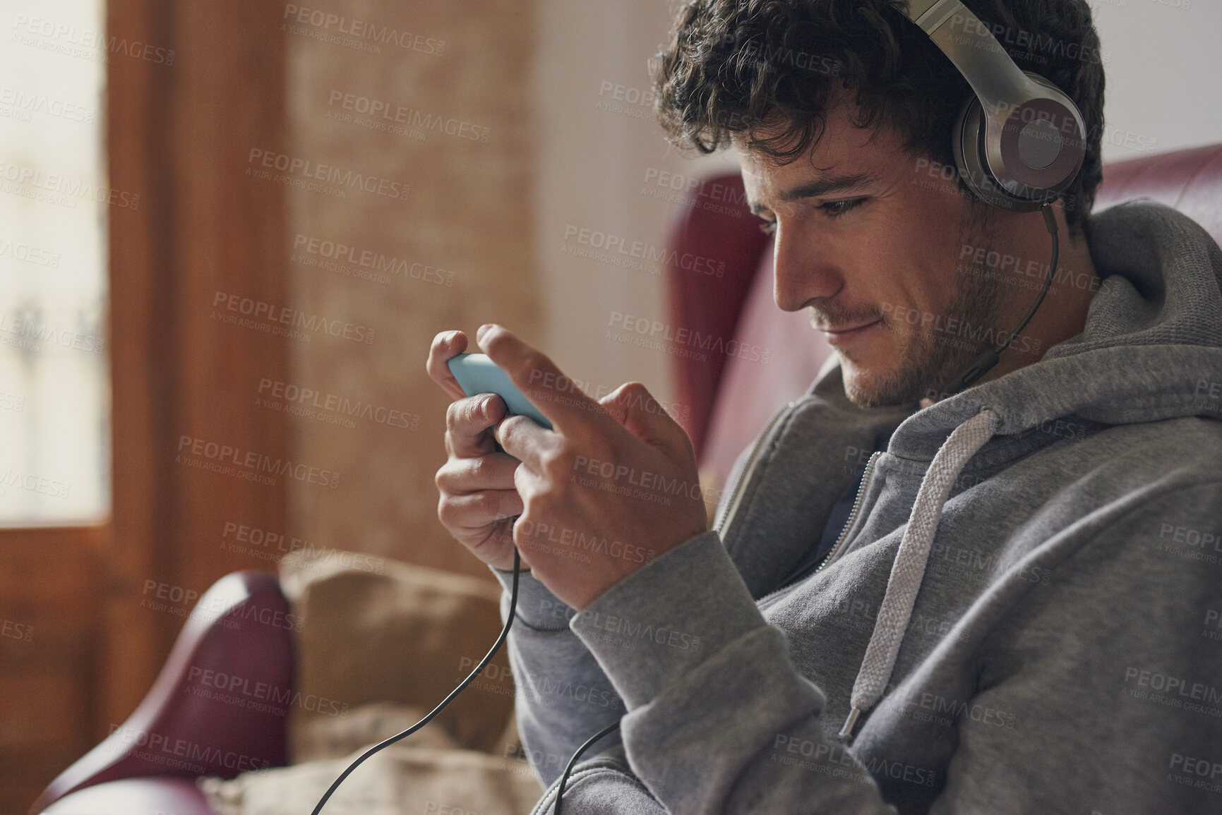 Buy stock photo Man, headphones and video game in home with phone, online entertainment and listen to music playlist. Person, esports gaming and audio tech in lounge for streaming radio, browse internet and website.