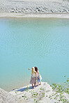 Beautiful girl friends taking smart phone selfies beautiful blue freshwater river on summer adventure vacation in nature