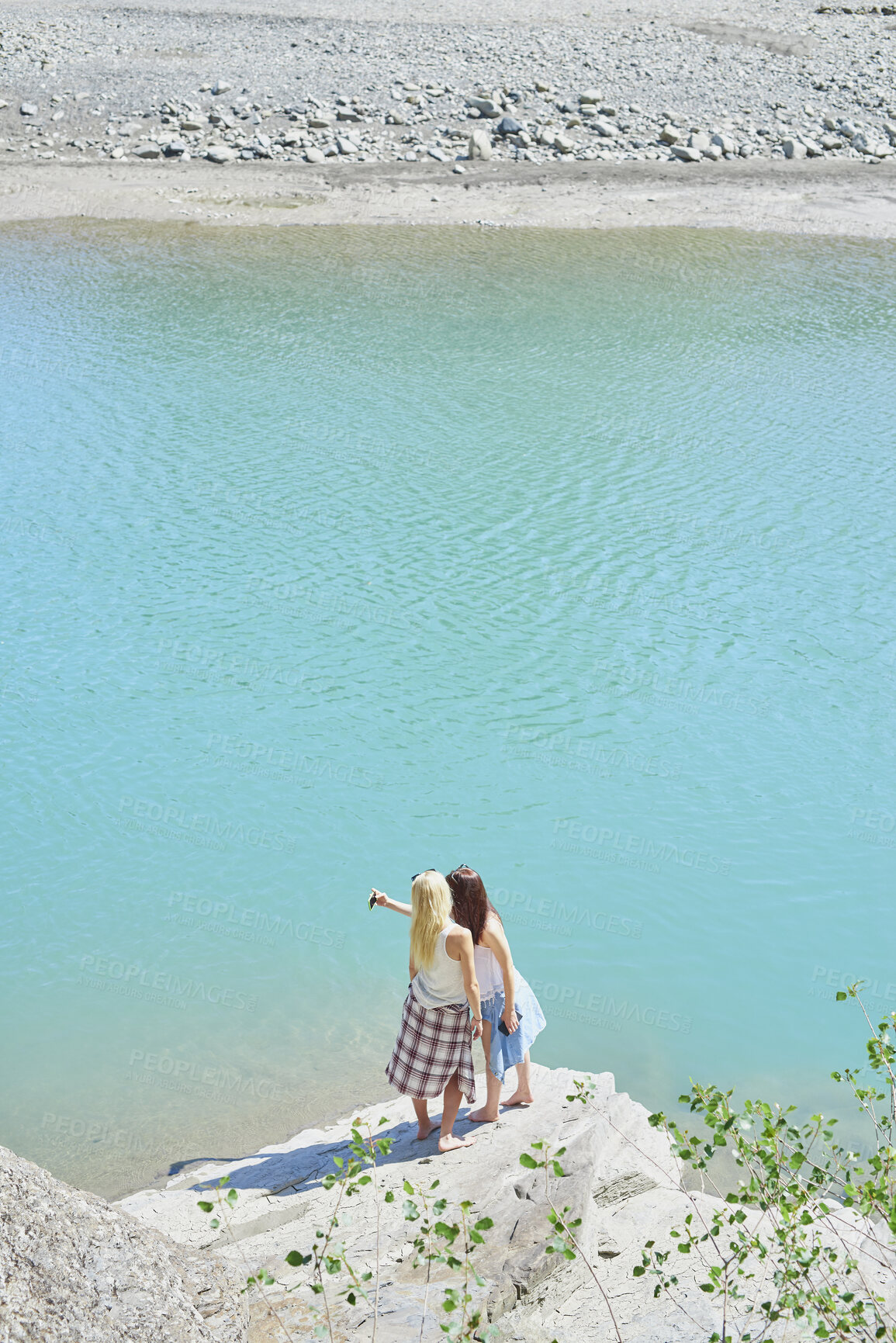 Buy stock photo Back, selfie and friends on cliff for holiday, photography and getaway with social media post. Above, travel and women on coastal ledge with space, profile picture update and quarry water on vacation