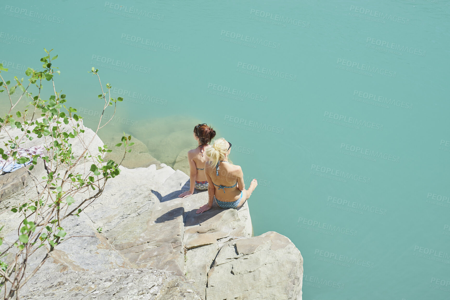 Buy stock photo Back, relax and women on cliff for travel, sunbathing and summer holiday with tropical view. Above, bikini and friends on coastal ledge with space, suntanning and quarry water on vacation getaway