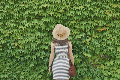 Buy stock photo Back, holiday and woman in nature with hedge, travel and botanical landmark on adventure trip. Wall, leaves and female person outdoor for tourism, scenic greenery and destination of vacation getaway