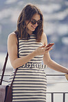 beautiful fashionable woman using smart phone technology at hotel on luxury vacation to communicate on social media