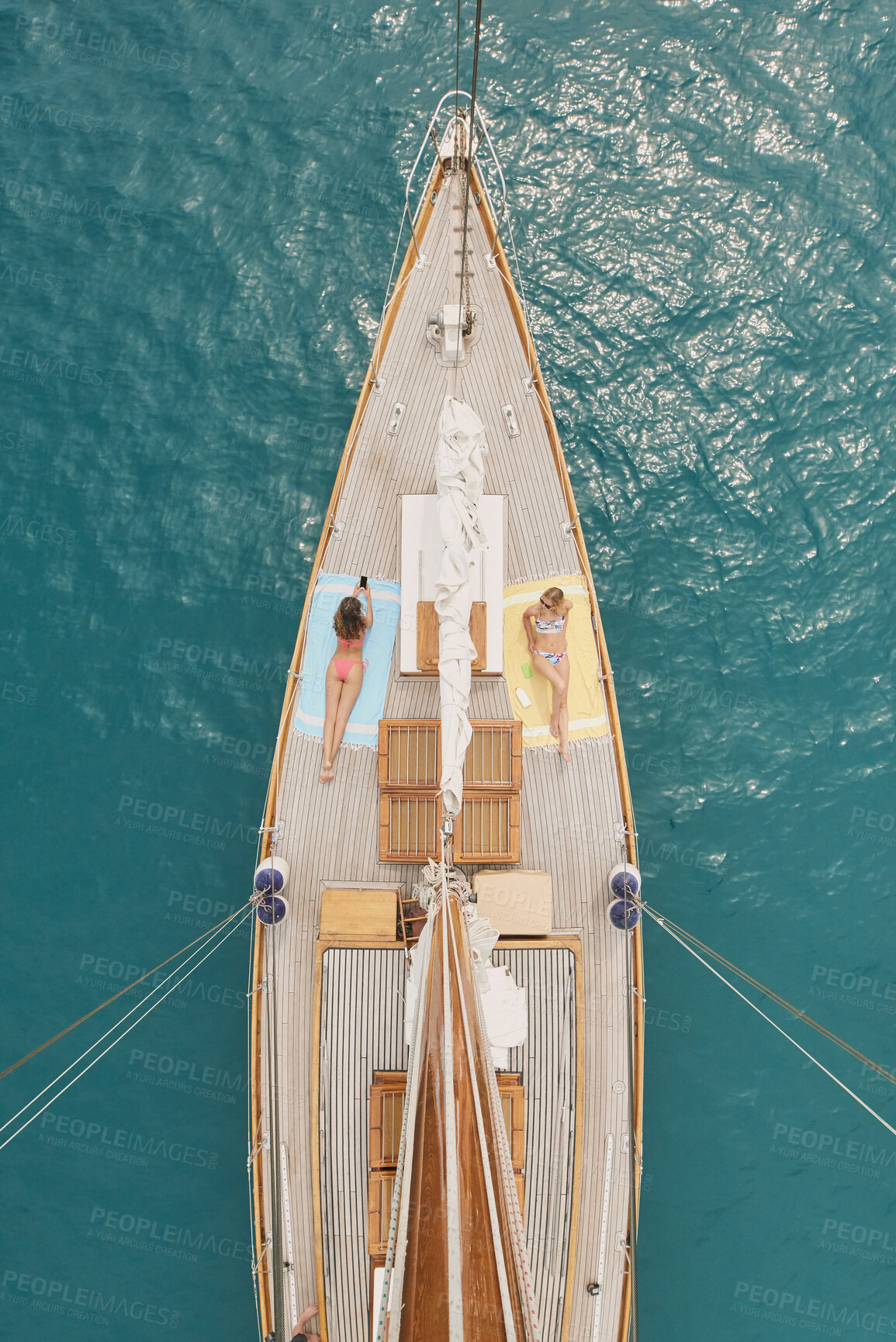 Buy stock photo Above, friends and travel in ocean with boat, summer holiday and relax with phone on luxury getaway. People, sunbathing outdoor and journey at sea with yacht, tech and tourist adventure for vacation.
