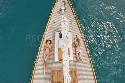 Buy stock photo Holiday, travel and relax with friends on yacht for summer vacation, suntanning and seaside adventure. Calm, sailing and tropical cruise with above of women on boat for ocean expedition and journey