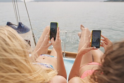 Buy stock photo Ocean, friends and photography on yacht with phone screen, travel together or summer holiday memories. Back, women relax or island vacation on boat with tech, social media post or picture of sea view