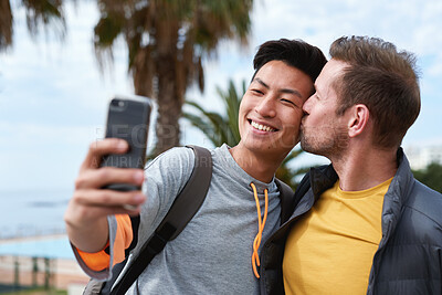 Buy stock photo Kiss, love and selfie with gay couple at beach together for bonding, memories or travel. App, photograph and vacation with happy men outdoor for affection, holiday or security in lgbt relationship