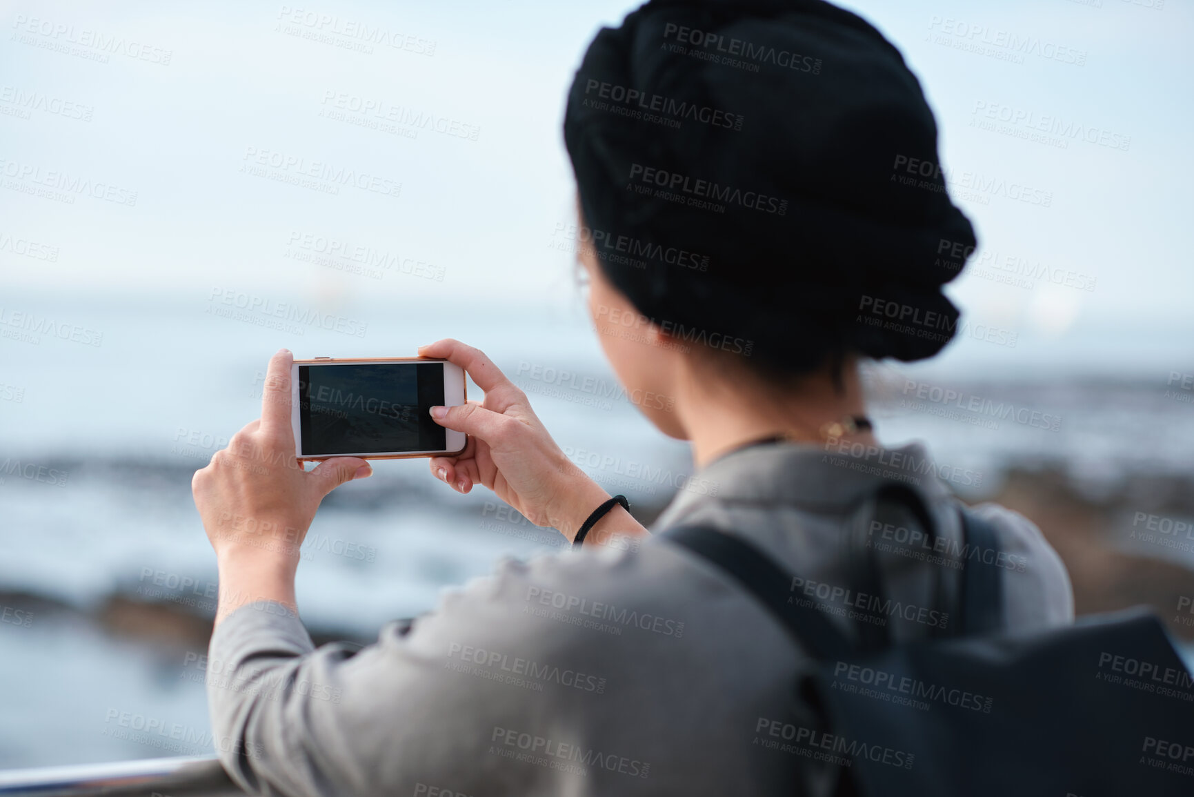 Buy stock photo Woman, travel or beach with phone camera for sightseeing memory, tourism or photography in nature. Back view, female person or tourist with mobile smartphone, app or screen on ocean coast for picture