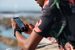 African american travel man using smartphone on beach texting with mobile phone sharing summer vacation wearing colorful hawaiian shirt