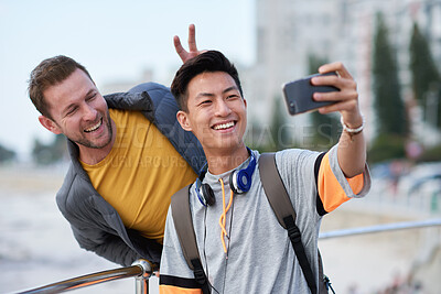 Buy stock photo Selfie, bunny ears or college students outdoor with fun, bonding or friendship post on academic break. Happy, playful or men with connection, university trip or memory capture for social media.