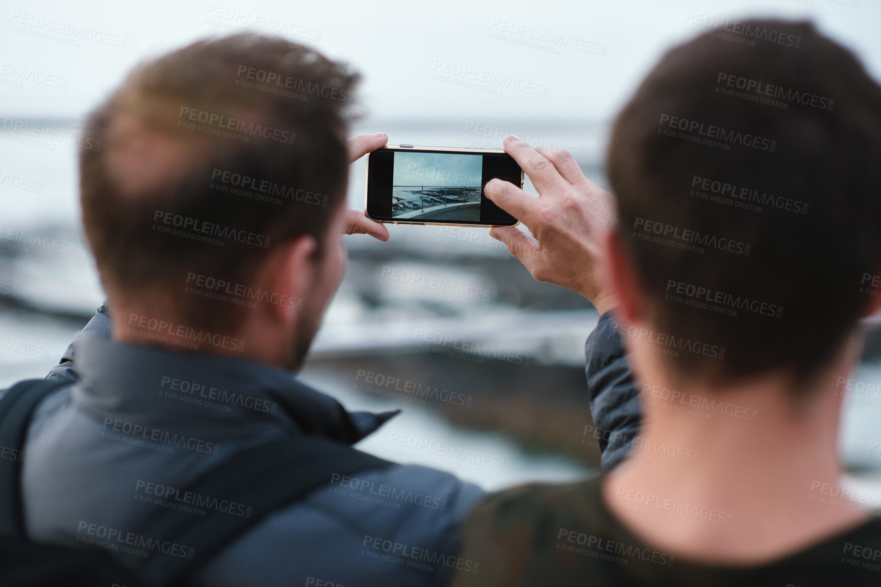 Buy stock photo Man, beach and friends with phone camera for photography, sightseeing or travel together in nature. Back view, male people or capture moment with mobile smartphone screen for picture on ocean coast