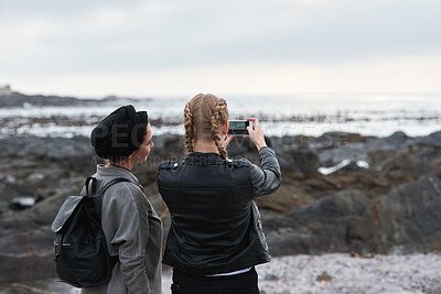 Buy stock photo Beach, picture and women with phone screen, bonding and share memory on social media app or website. Coastline, photo and friends on holiday in nature, space and people with mobile for travel vlog