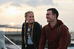 Young couple on seaside chatting enjoying hanging out on waterfront beach at sunset