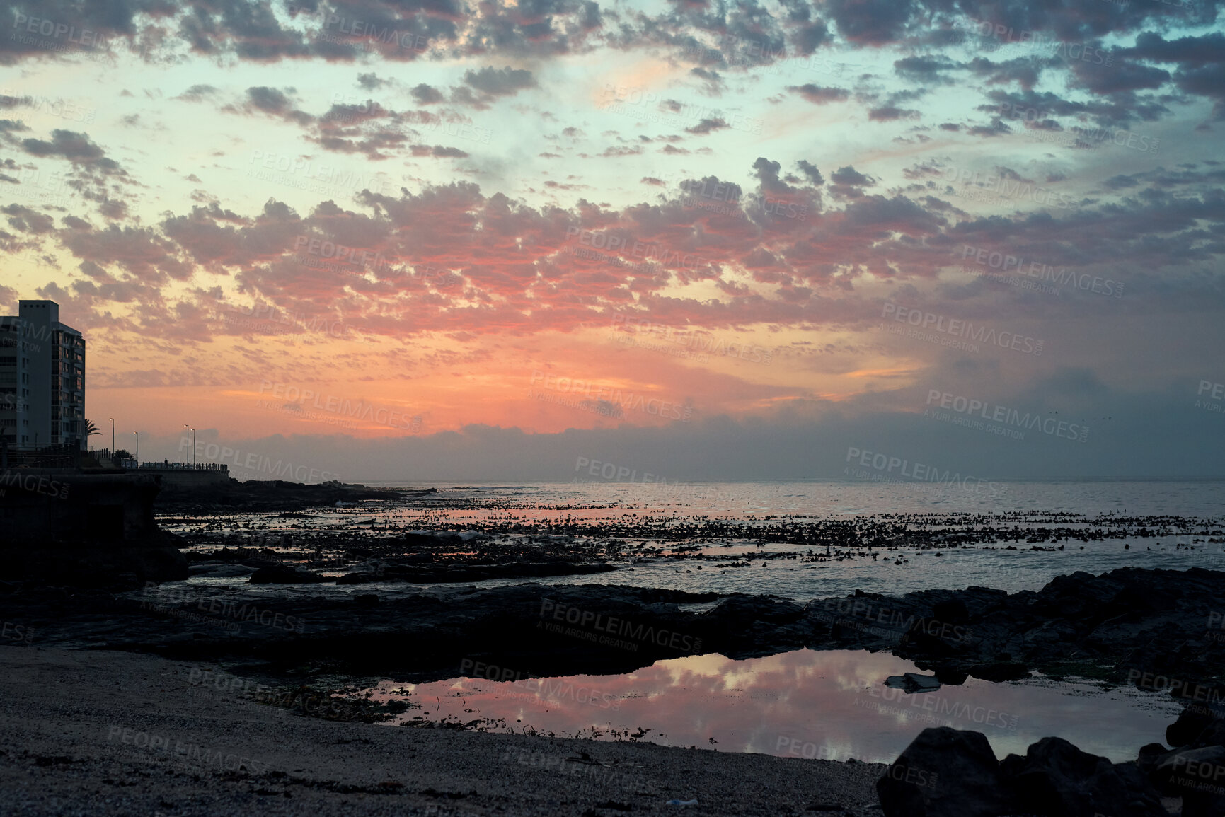 Buy stock photo Rocks, sky and sunset with view of ocean from seaside for background or scenic wallpaper. Clouds, seascape and space with water in colorful environment for calm dusk, nightfall or twilight scenery