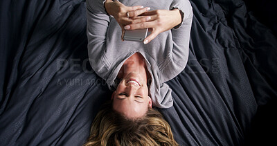 Buy stock photo Above, smile and woman in bed with phone, text or reading funny meme on social media in home. Laugh, relax or person in bedroom on mobile app for typing message, morning notification or communication