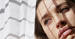 Woman, window and anxiety in home with thinking, loneliness or regret with reflection for decision. Sad, memory and person with perspective for loss, grief and mental health for morning in house