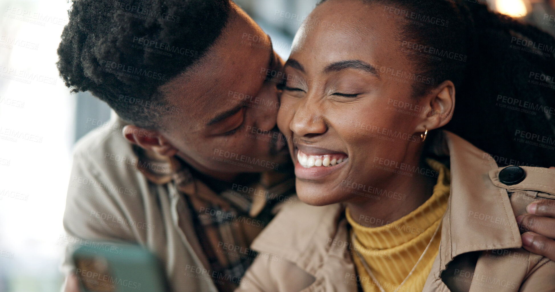 Buy stock photo Love, black couple and kiss with phone in cafe for romantic date, text message and web browsing. Trust, people and affection with mobile app in coffee shop for social media, status update and loyalty