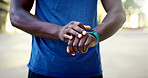 Hands, fitness and black man with watch in city for outdoor workout, tracking performance or app. Active, male person or checking steps with wristwatch for monitoring exercise, training or heart rate