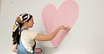 Painting, wall and woman with heart for home decoration, remodeling and diy for interior design. House, painter and person with shape and paintbrush for inspiration, creative project and makeover