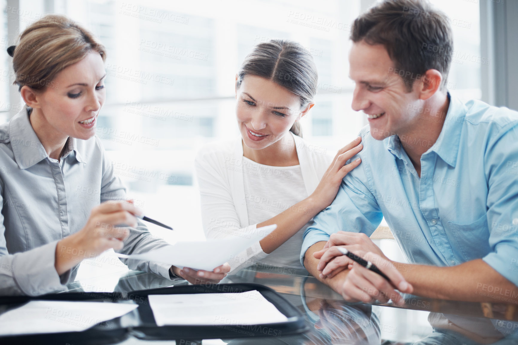 Buy stock photo Finance, happy couple and document in office with consultant, insurance update and holding hands. Paperwork, married people and broker in meeting for investment guide to qualify for premium cover