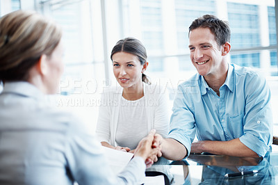 Buy stock photo Couple, finance and handshake with financial advisor for agreement, consulting or investment. Deal, meeting or thank you and broker shaking hands with people in office for portfolio growth or success