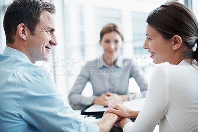 Buy stock photo Love, couple and financial advisor in office, holding hands and smile for asset management. Happy man, woman and investment consultant with clients for support, future security and budget review