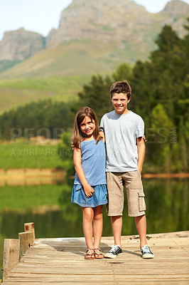 Buy stock photo Care, children and siblings hug at lake on vacation together, love or portrait on jetty with smile. Kids, brother and sister with embrace on dock for summer trip, tourism and travel with happiness