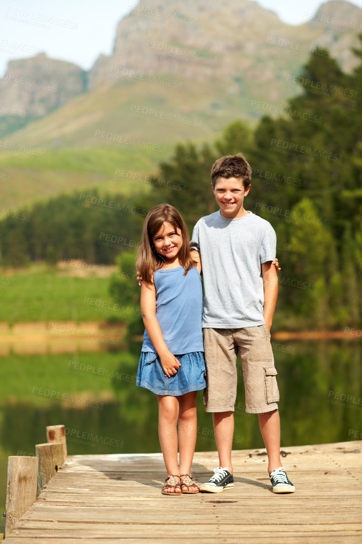 Buy stock photo Care, children and siblings hug at lake on vacation together, love or portrait on jetty with smile. Kids, brother and sister with embrace on dock for summer trip, tourism and travel with happiness