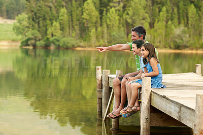 Buy stock photo Smile, father and pointing with children at lake, adventure and scenic view on holiday trip. Happy, man or hand gesture in nature with kids, wildlife observation and lakeside for sightseeing vacation