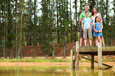 Buy stock photo Portrait, family and smile outdoor by lake for summer holiday, vacation and together. Low angle, pier and happy man, woman and children in nature to relax, bonding and space with love and care