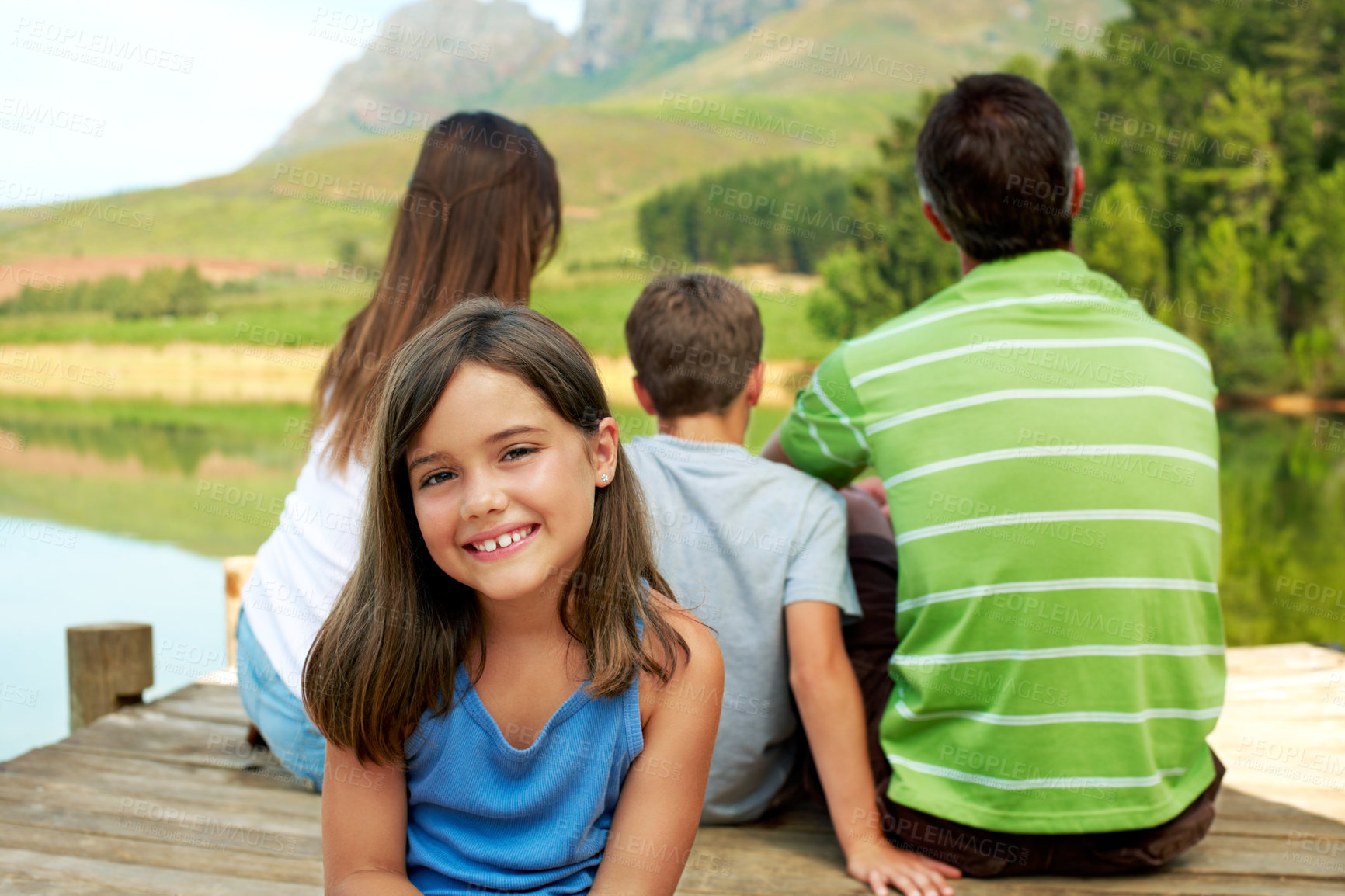 Buy stock photo Family, vacation and happy kid on lake dock, relax and portrait outdoor for summer travel. Girl, child and break at pier on holiday, countryside tourism and chill with parents by water in nature