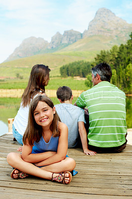 Buy stock photo Portrait, vacation and happy kid on lake dock, relax and family outdoor for summer travel. Girl, child and break at pier on holiday, countryside tourism and chill with parents by water in nature