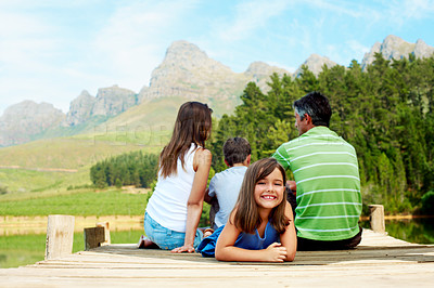 Buy stock photo Family, vacation and happy kid on lake jetty, portrait and relax outdoor for summer travel. Girl, child and rest at pier on holiday, countryside tourism and sibling with parents by water in nature