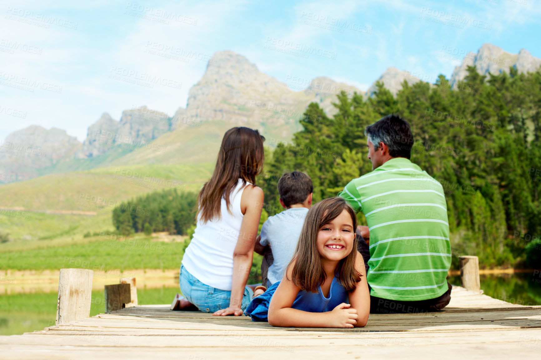 Buy stock photo Family, vacation and happy kid on lake jetty, portrait and relax outdoor for summer travel. Girl, child and rest at pier on holiday, countryside tourism and sibling with parents by water in nature
